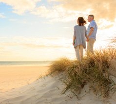 Paar am Strand blickt auf das Meer